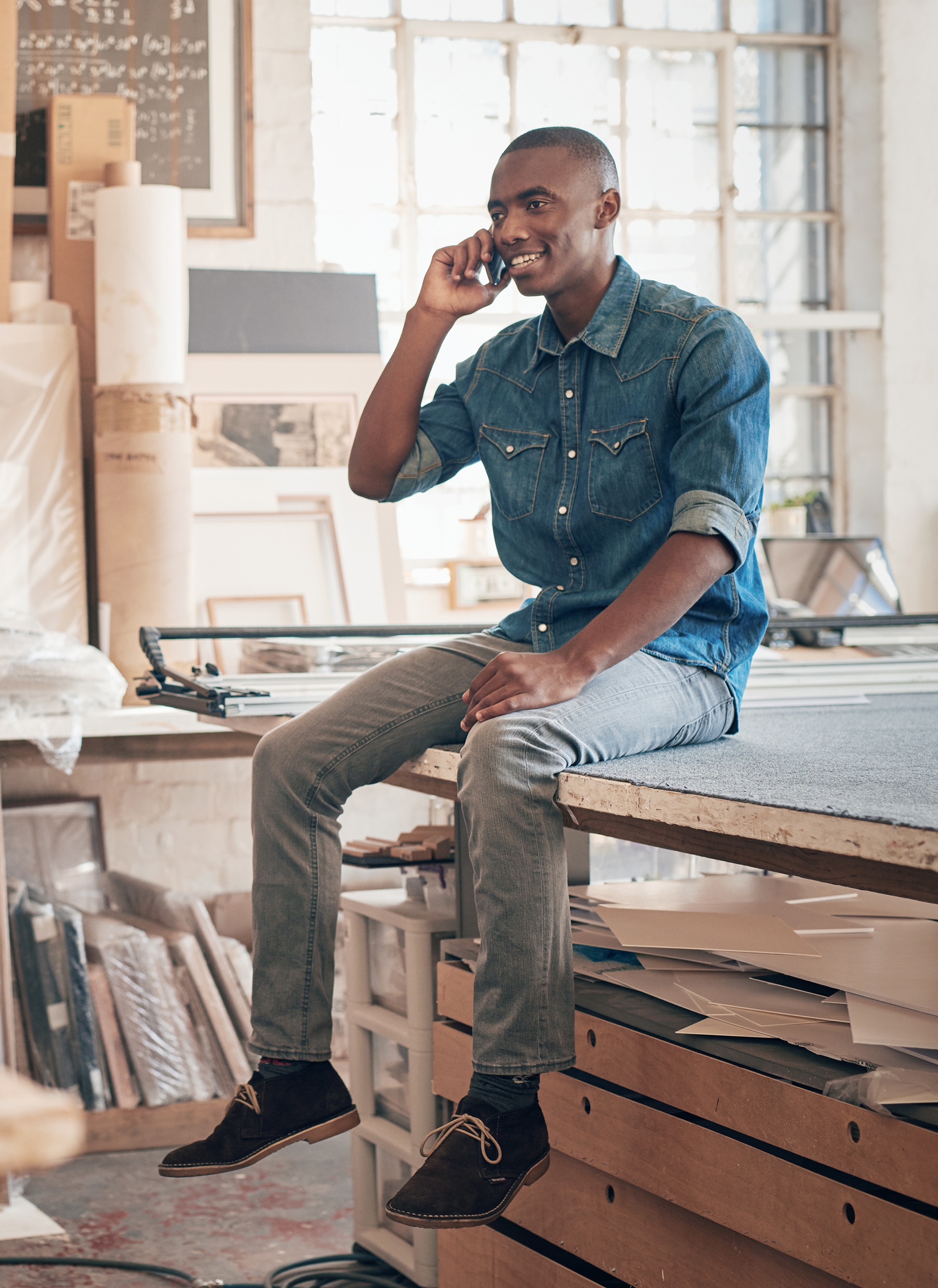 Handsome,African,Designer,Talking,On,Phone,In,His,Studio Handsome African designer talking on phone in his studio